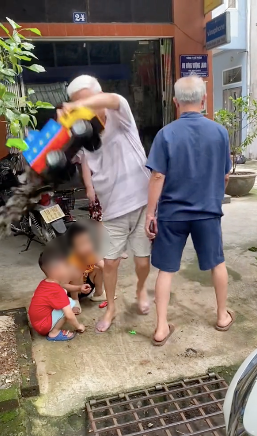 Cụ ông bực tức đổ hết sỏi trong xe của các bé đang chơi rồi ném xuống đất trước sự ngơ ngác của các bé.