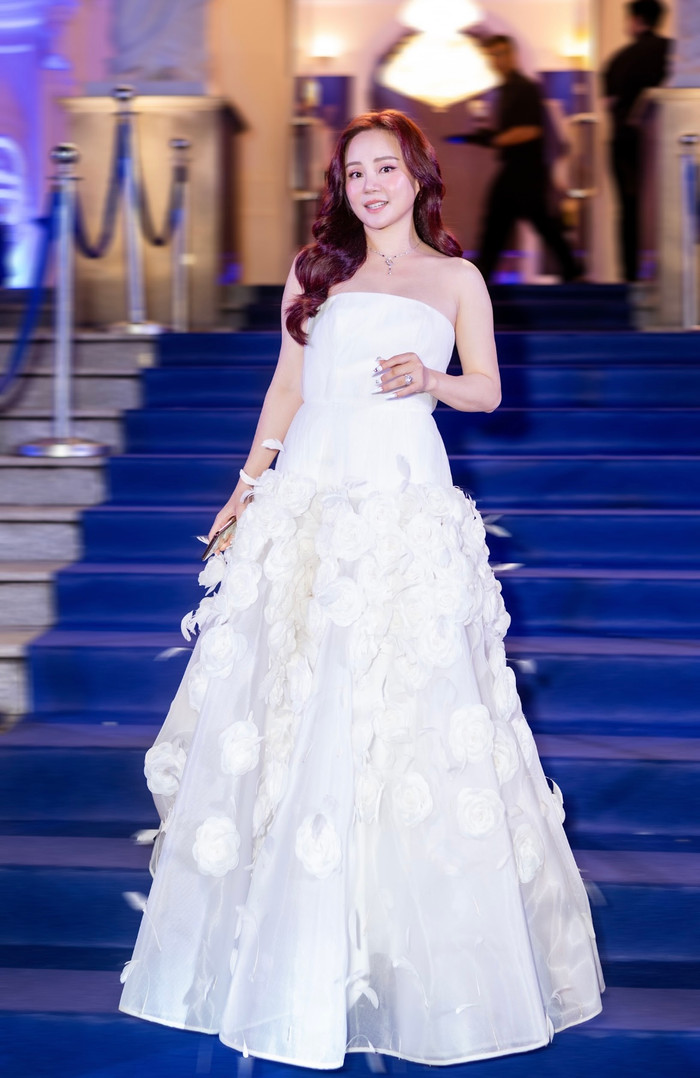 Vy Oanh hóa 'công chúa' cùng chiếc váy trắng với điểm nhấn là những cánh hoa dưới phần đuôi váy.