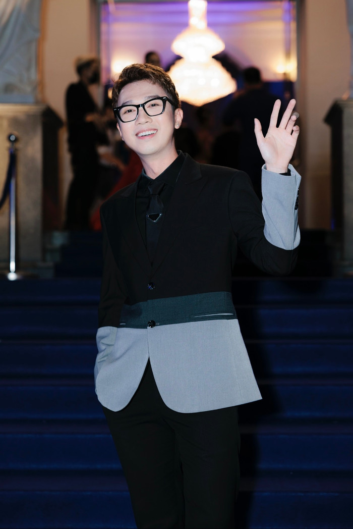 MC Minh Xù bảnh bao với bộ vest đen sang trọng. Với chiếc mắt kính không tròng, Minh Xù nổi bật với vẻ ngoài trẻ trung, sang trọng.