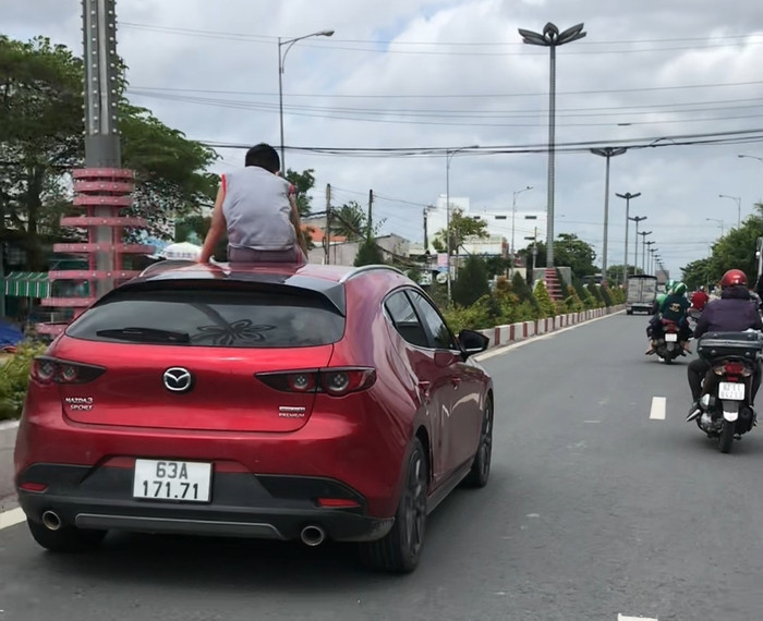 'Đứng tim' cảnh bé trai ngồi vắt vẻo trên mui xe ô tô đang lao vun vút trên QL1A Ảnh 2