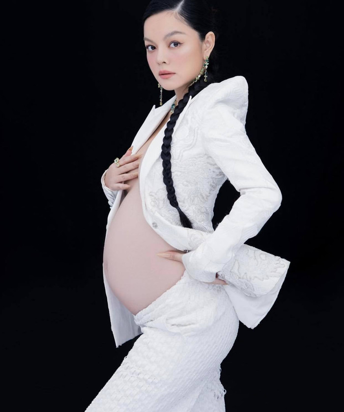 Mẹ bầu diện trang phục trắng, phô trọn bụng bầu.