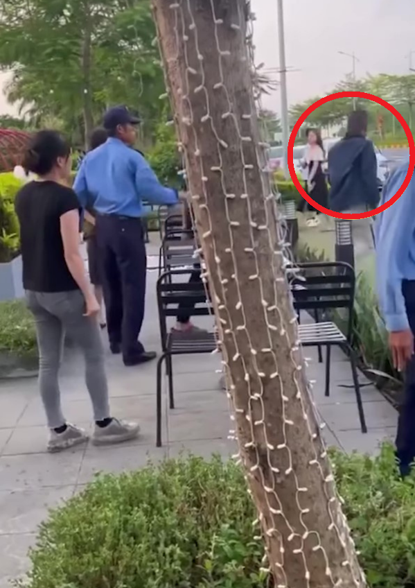 Nam thanh niên (khoanh đỏ) ra tay đanh cô gái bị nhiều người xung quanh ngăn cản và dạy cho một bài học. 