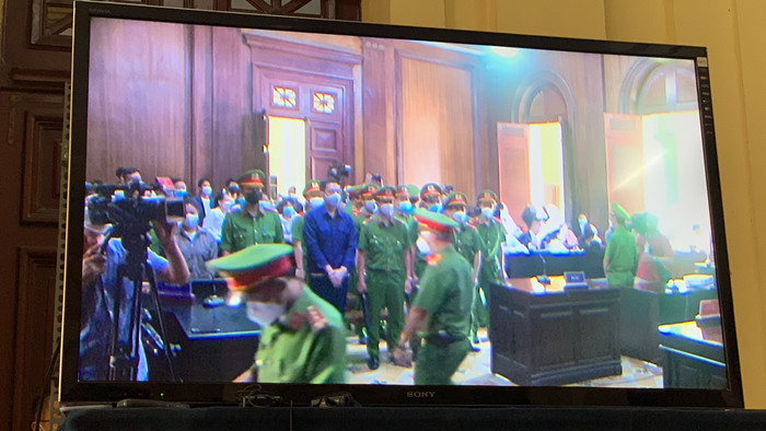 Các phóng viên theo dõi vụ xét xử qua màn hình tivi