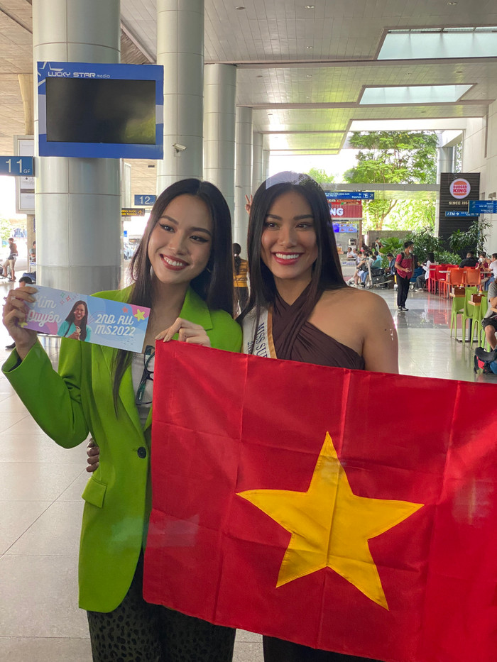 Thủy Tiên chào đón Kim Duyên với lá cờ đỏ sao vàng của Việt Nam.