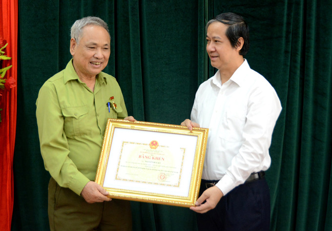 Cụ ông Nguyễn Huy Kỳ nhận bằng khen từ Bộ trưởng Bộ GD&ĐT Nguyễn Kim Sơn. Ảnh: MOET