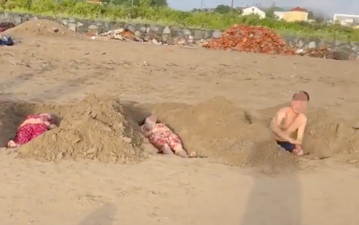 Lạ lùng chuyện nhóm du khách đào hố giống như huyệt mộ để nằm tắm cát Ảnh 2