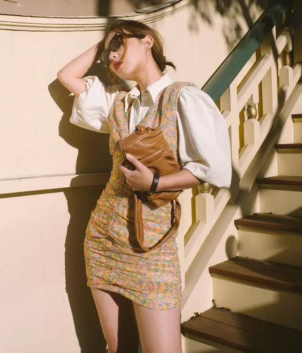 Váy hoa ngắn phối cùng áo blouse tay bồng sẽ khiến bạn trở nên sang trọng, yêu kiều như một nàng tiểu thư. Đừng quên mang theo một chiếc túi kẹp nách để tổng thể thêm thời thượng.