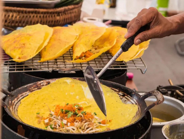 Bánh xèo miền Tây được đổ trong một chiếc chảo lớn, khi đổ nghe một tiếng 'xèo xèo'