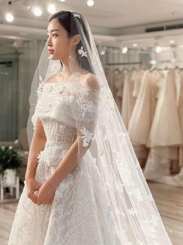 Một mẫu váy cưới khác được nàng hậu chọn lựa, có thiết kế hở vai, thân váy đính kèm nhiều đá lấp lánh