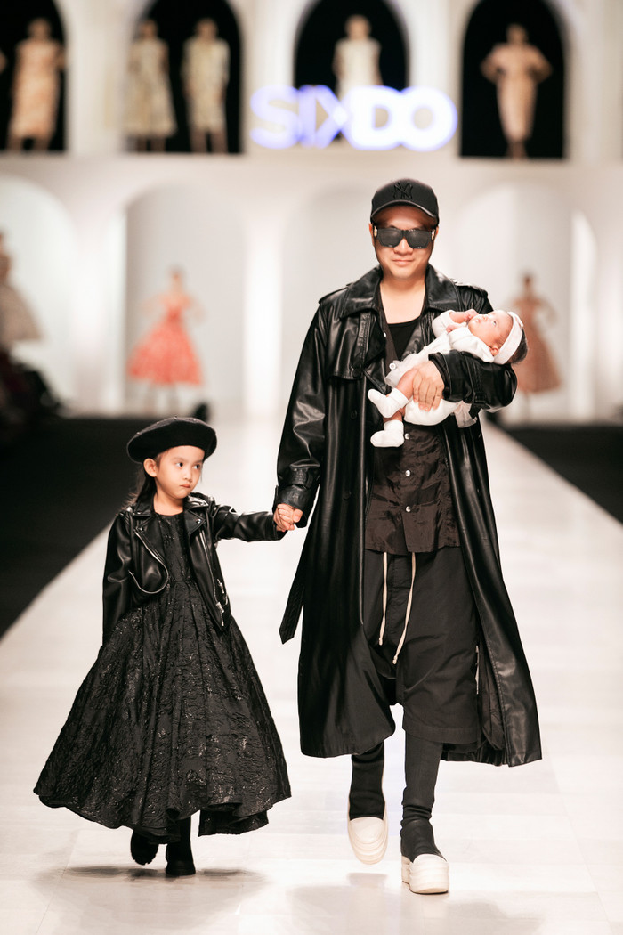 Nhà thiết kế Đỗ Mạnh Cường bồng bế con nuôi thứ 10 trên tay trong show diễn mới đây.