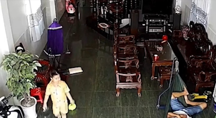Bé gái ra phòng khách chơi thì phát hiện bố đang nằm ngủ trên võng. Ảnh cắt từ clip