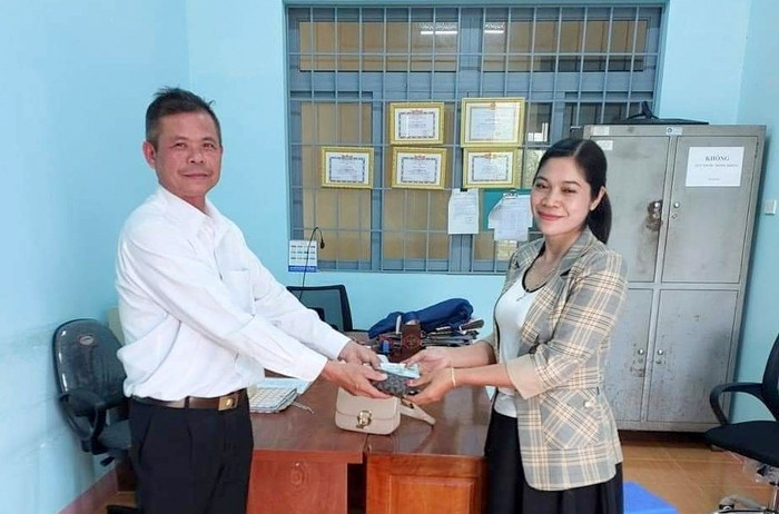 Anh Bùi Văn Toàn trao trả lại tài sản cho người đánh rơi trước sự chứng kiến của Công an xã Nam Bình