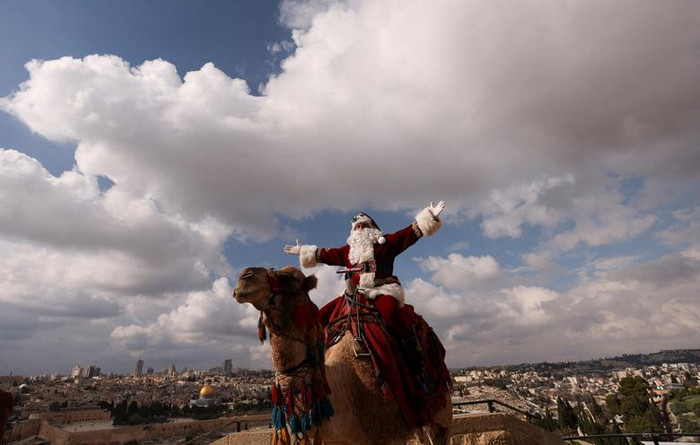 Ông già Noel khi cưỡi lạc đà trong mùa Giáng sinh trên núi Olives ở Jerusalem