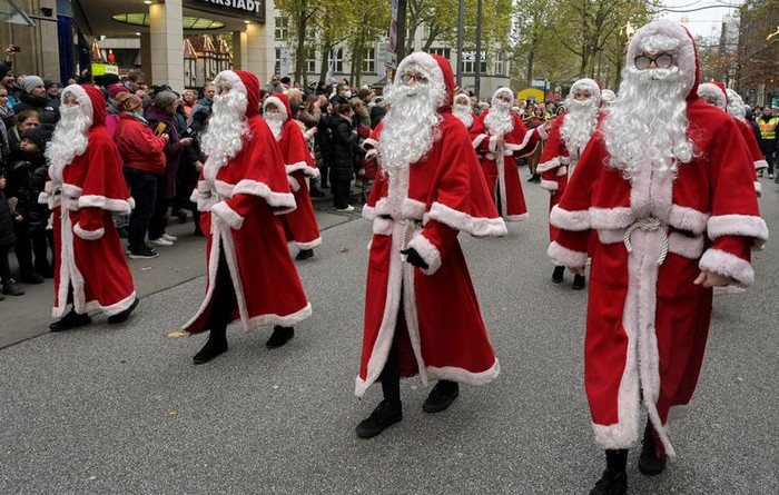 Nhiều ông già Noel đang giễu hànhtrên một con phố mua sắm sầm uất, ở Hamburg, Đức 