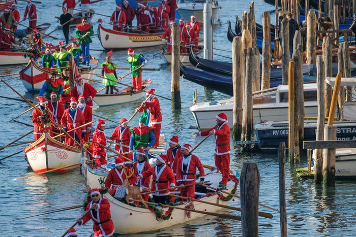 Nhiều người hóa trang thành ông già Noel chèo thuyền trong cuộc đua thuyền Giáng sinh dọc theo Kênh đào Grand ở Venice, Ý, ngày 18 tháng 12 năm 2022.
