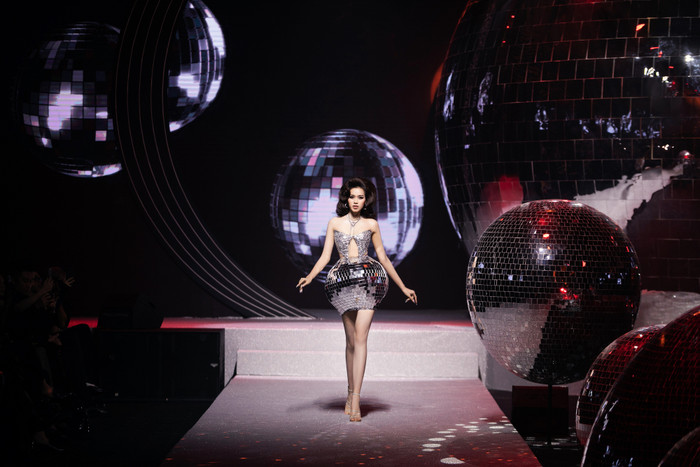 Sự lộng lẫy, hoành tráng của phần 1 càng được đẩy lên cao trào khi Đỗ Thị Hà ở vị trí vedette có màn sải bước duyên dáng trong trang phục corset kinh điển kết hợp với phần váy ngắn mô phỏng quả cầu disco, phản chiếu ánh sáng theo từng bước đi uyển chuyển.  