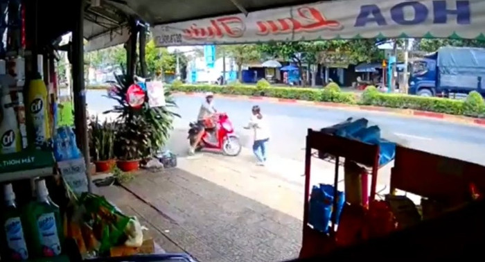 Thanh niên vừa lấy trộm được 2 thùng bia bị chủ quán bắt quả tang và xông ra ngăn cản. Ảnh cắt từ clip