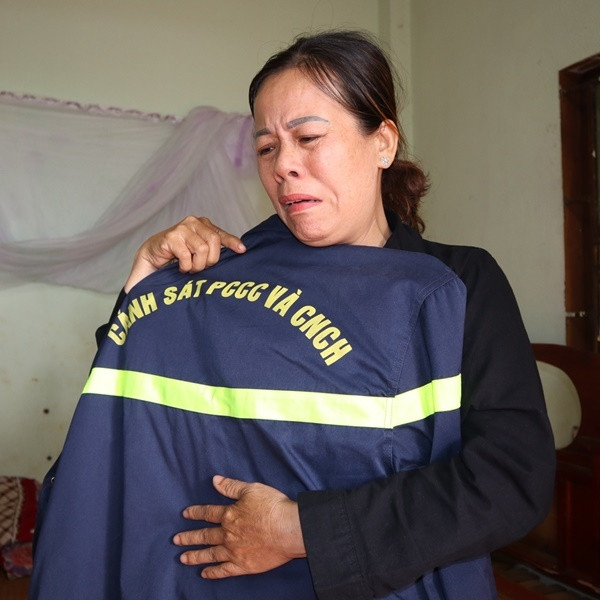 Mẹ của chiến sĩ Sang đau đớn, ôm di vật của con trai. (Ảnh: Thanh Niên)