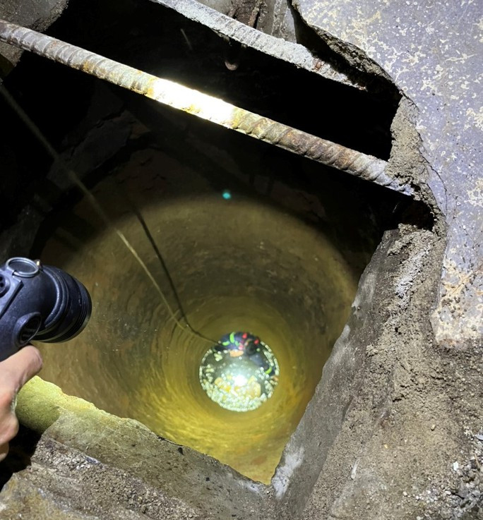 Lực lượng chức năng giải cứu hai cha con mắc kẹt dưới giếng hoang sâu hơn 20m. (Ảnh: Người lao động).