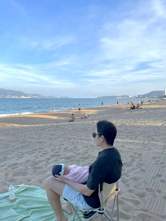 Ông bố Phan Mạnh Quỳnh trầm tư bế con trai nhìn xa xăm.