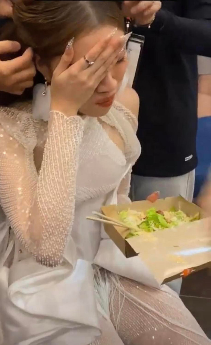 Thanh Thanh Huyền ăn vội một ít salad, bên cạnh là đội ngũ đang làm tóc cho cô.