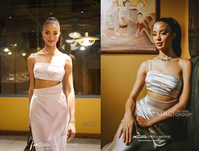 Về phần Á hậu 2 - Andreína Martínez lại có phần lép vế hơn so với R'Bonney Gabriel trong bộ cánh đầu tiên tại Việt Nam. Cô vẫn lựa chọn kiểu tóc cột cao, đầm hở eo đơn giản có màu trắng dịu mắt, nên có phần nhàm chán hơn so với loạt hình ảnh trong chuyến công tác trước đây. 