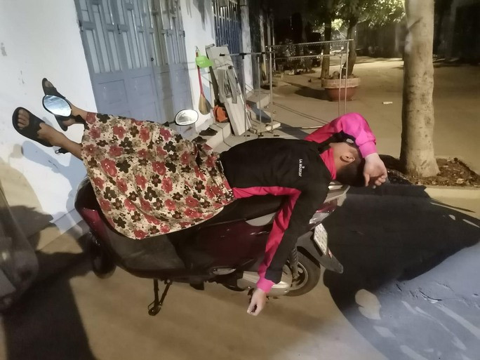 Hình ảnh được cho là của 2 chủ nhân 2 chiếc xe máy ngủ ngoài phòng trọ để bảo vệ tài sản của mình