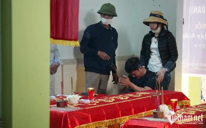 Người chồng khóc nức nở trước di ảnh của vợ và 2 con nhỏ. Ảnh: VietNamNet