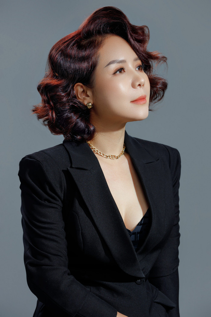 Nhà tạo mẫu tóc đã lựa chọn kiểu tóc bob ngắn xoăn bồng bềnh với màu nâu trầm tôn lên gương mặt của người phụ nữ.