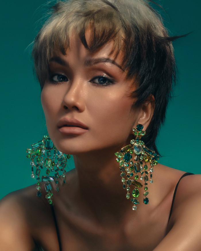  Ở layout đầu tiên, Hoa hậu H'Hen Niê thể hiện hình ảnh quyến rũ, gợi cảm với áo hai dây cắt xẻ, tóc ngắn hai màu vàng đen ấn tượng. Đôi bông tai to và phụ kiện kèm theo giúp tôn vinh làn da nâu khỏe khoắn của H'Hen Niê. 