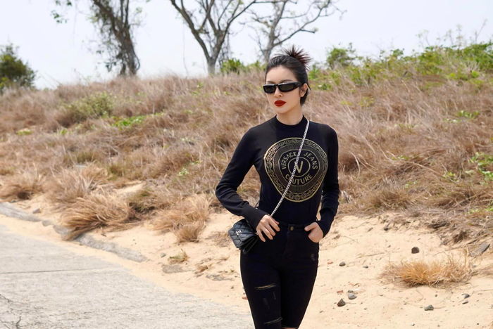 Tiếp đến là mẫu áo đến từ thương hiệu Versace tay dài được kết hợp với chiếc túi Chanel nhỏ cũng trị giá không nhỏ nhưng về phần dây túi lại có điểm khác hẳn so với mẫu gốc từ hãng.&nbsp;