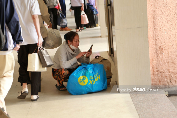 Người dân lỉnh kỉnh đồ đạc chờ đợi xe ở các sảnh của Bến xe Mỹ Đình.