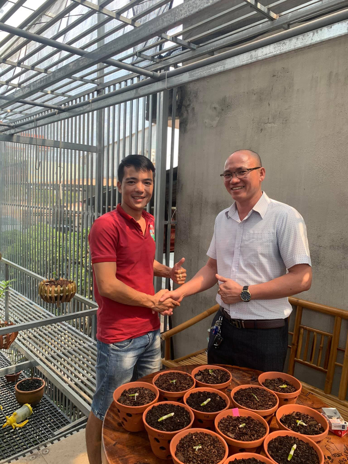 Anh Phạm Hoàng Thái (bên trái) hướng dẫn cách chăm sóc cho người bạn có cùng đam mê trồng lan như anh