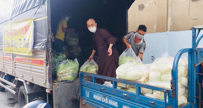 Đại đức Thích Pháp Như xắn tay áo khuân vác rau quả cho kịp chuyến xe sớm giao các bếp ăn 0 đồng trước 12h trưa