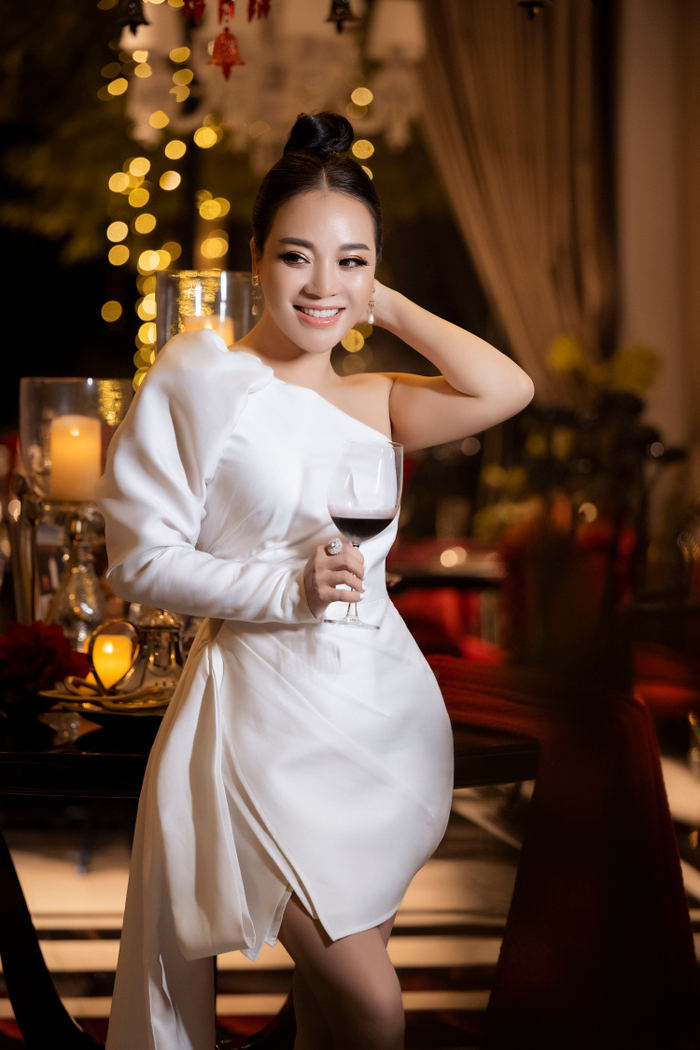 Chủ nhân buổi tiệc diện đầm trắng sang trọng, thanh lịch nhưng vẫn toát lên vẻ gợi cảm bởi thiết kế lệch vai.