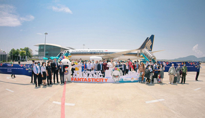 Hoa hậu Lương Thuỳ Linh cùng Top 3 Hoa hậu Du lịch Đà Nẵng 2022 chụp hình cùng các hành khách quốc tế đầu tiên đặt chân xuống sân bay Đà Nẵng